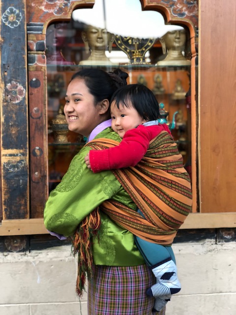 Bhutanese mother carries her child on her back