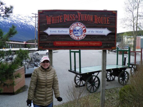 Lexi in front of the White Pass & Yukon Route sign before she took the three-hour train ride